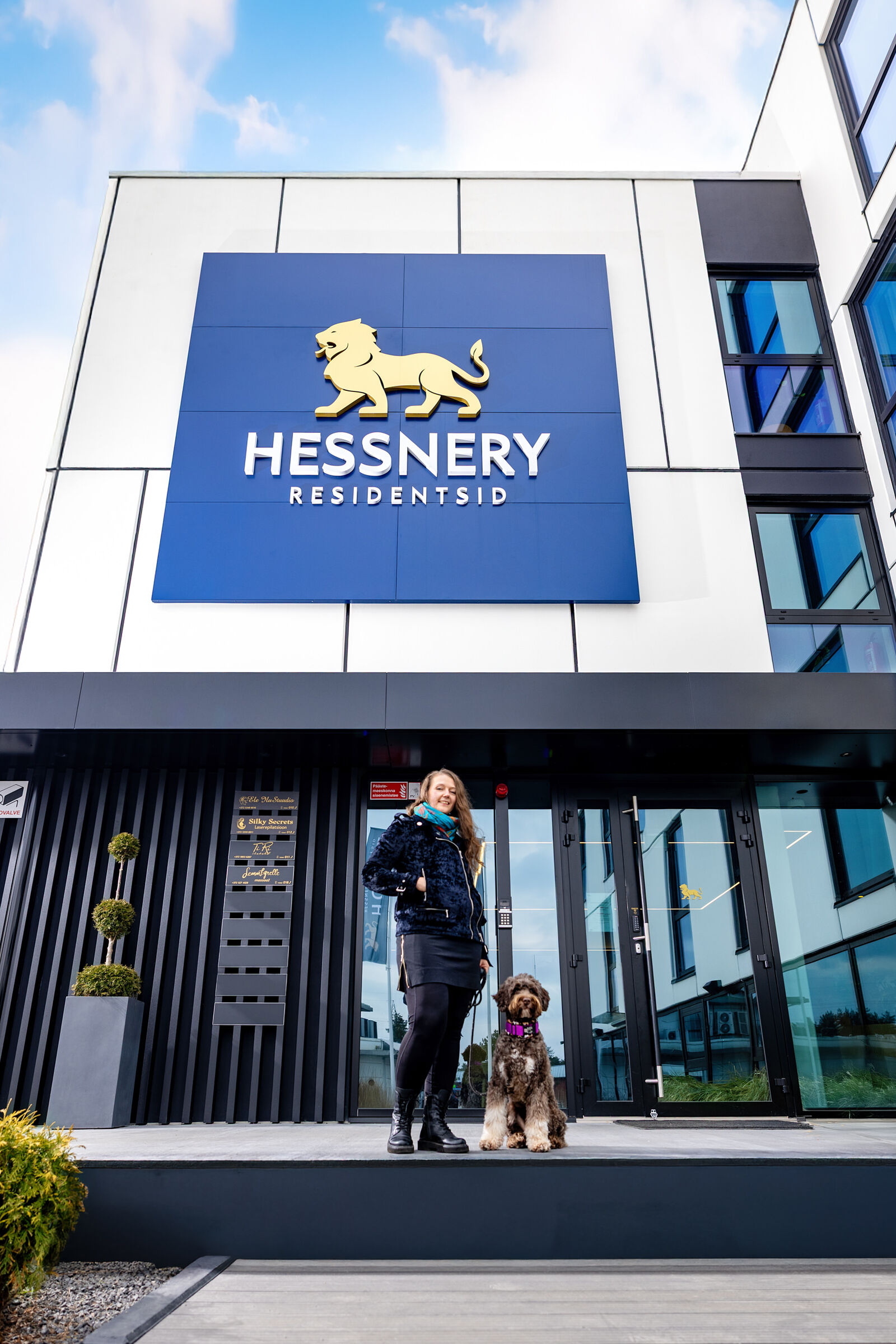 Külaline koeraga Hessnery sissepääsu juures — lemmikloomasõbralik hotell